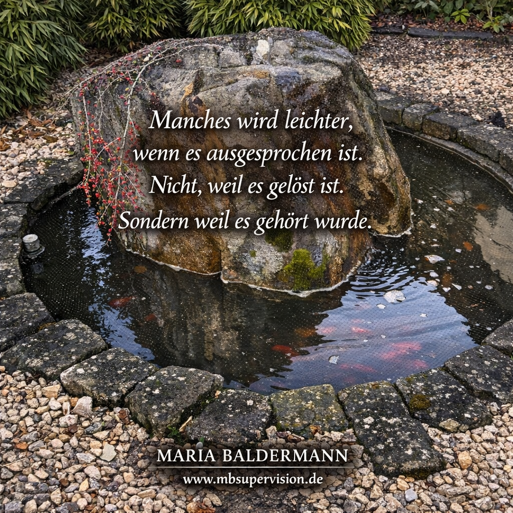 Ein Felsbrocken in einem mit Steinen eingefassten Goldfischteich. Davor der Text: Manches wird leichter, wenn es ausgesprochen ist. Nicht, weil es gelöst ist. Sondern weil es gehört wurde.