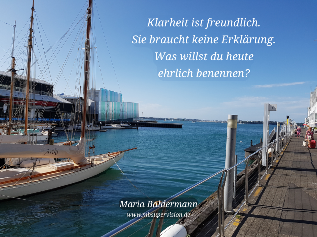 Eine Hafenansicht. Darüber der Text: Klarheit ist freundlich. Sie braucht keine Erklärung. Was willst du heute ehrlich benennen?
