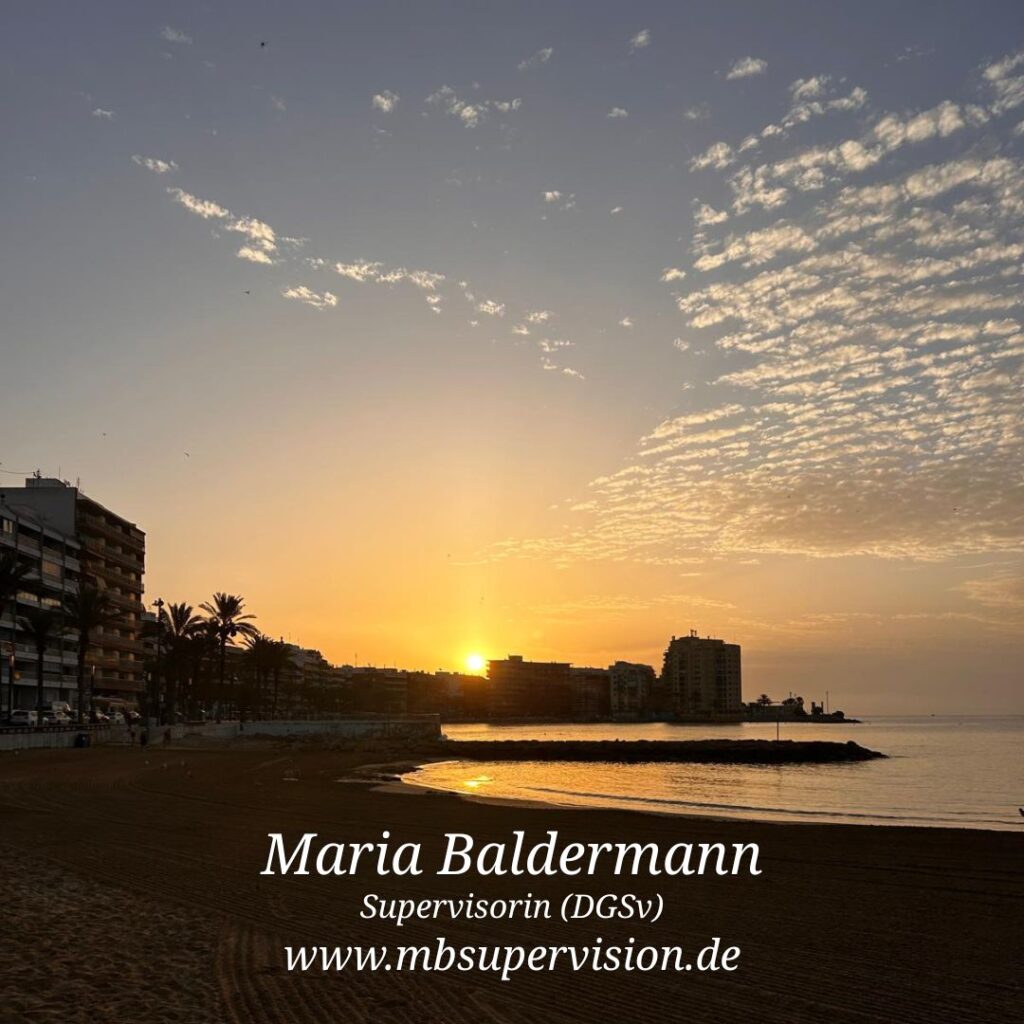 Die Sonne steht tief am Horizont und taucht den Himmel in warme Gelb- und Orangetöne. Über dem Wasser und den Gebäuden am Ufer ziehen sich lockere Wolkenfelder. Links sind mehrstöckige Gebäude und Palmen zu sehen, rechts ragt eine Landzunge ins Meer. Der Sandstrand im Vordergrund liegt im Schatten. Unten im Bild sind der Name 'Maria Baldermann', die Berufsbezeichnung 'Supervisorin (DGSV)' und die Internetadresse 'www.mbsupervision.de' zu lesen.
