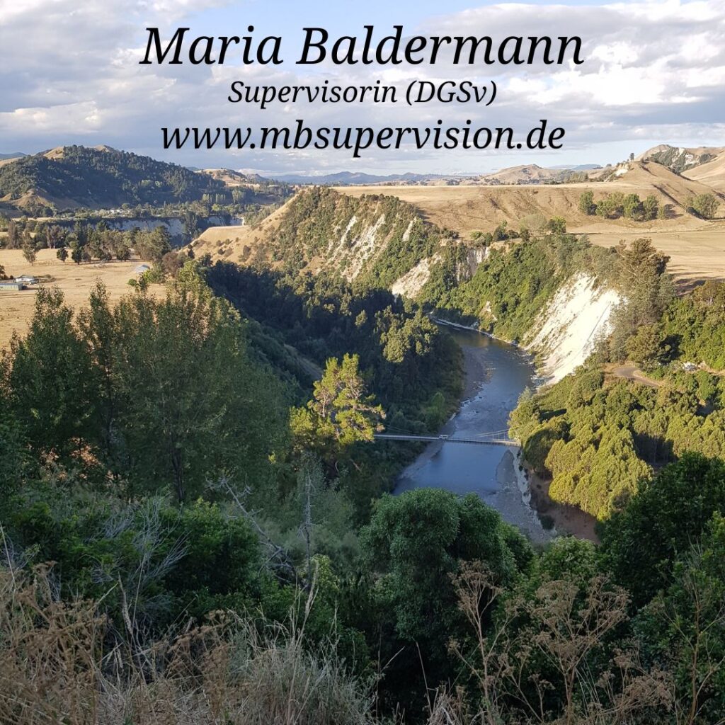 Ein Fluss schlängelt sich durch eine hügelige Landschaft mit steilen, hellen Felswänden und dicht bewachsenen Uferbereichen. Im Vordergrund wachsen Sträucher und Bäume, während rechts und links offene Felder und sanfte Hügel zu sehen sind. Über dem Fluss verläuft eine schmale Brücke. Der Himmel ist bewölkt. Im oberen Bildbereich sind der Name 'Maria Baldermann', die Berufsbezeichnung 'Supervisorin (DGSV)' und die Internetadresse 'www.mbsupervision.de' zu lesen.