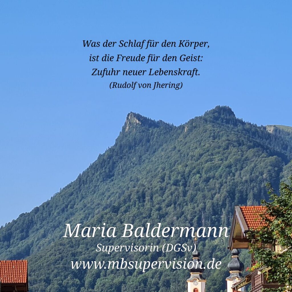 Im Vordergrund sind die Dächer und zwei Kirchtürme zu sehen. Dahinter erhebt sich ein bewaldeter, markanter Berg unter klarem, blauem Himmel. Im oberen Bildbereich steht ein Zitat: 'Was der Schlaf für den Körper, ist die Freude für den Geist: Zufuhr neuer Lebenskraft. (Rudolf v. Jhering)'. Unten im Bild sind der Name 'Maria Baldermann', die Berufsbezeichnung 'Supervisorin (DGSV)' und die Internetadresse 'www.mbsupervision.de' zu lesen.